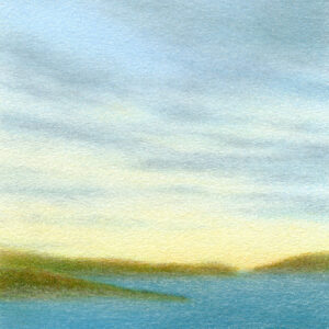 Evening skies with hazy clouds in delicate blue and yellow colors over green grass and deep blue body of water.